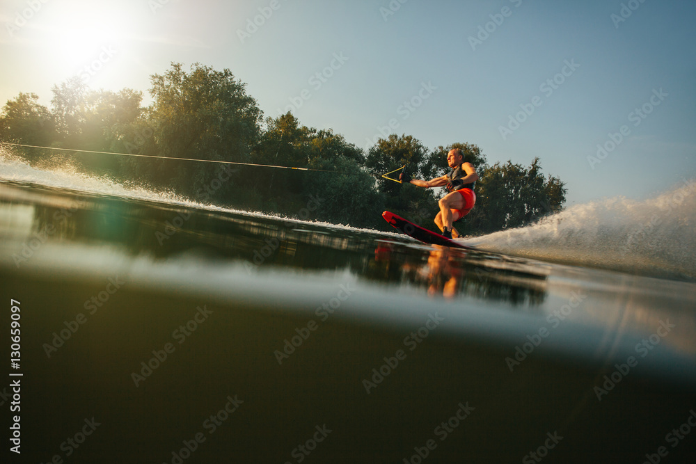 Athlete water skiing behind a boat Athlete water skiing behind a boat