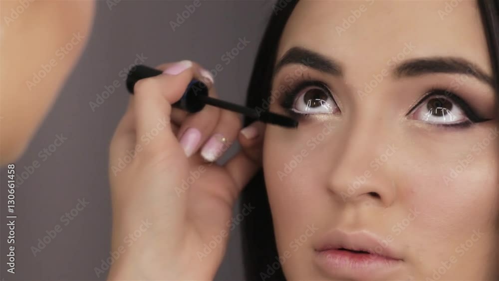 Make up artist doing professional make up of beautiful woman Make up artist doing professional make up of beautiful woman