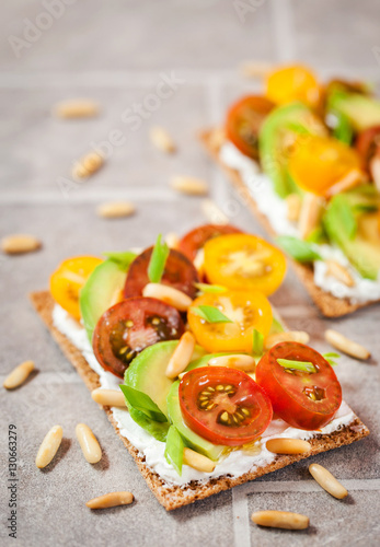Сrisp bread toast  with cream cheese, fresh avocado, cherry tom