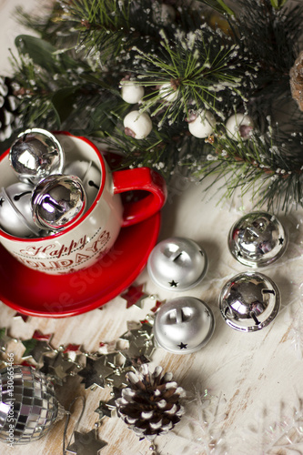 A beautiful christmas spirit background composition with a coffee -sup and jingle bells.