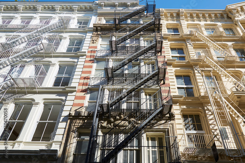 Building facades with fire escape stairs, sunny day in Soho, New York © andersphoto