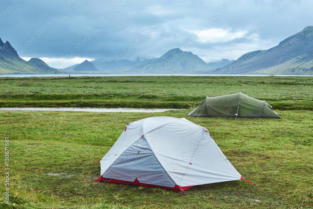 Travel to Iceland. Beautiful Icelandic landscape with mountains, sky and clouds. Trekking in national park Landmannalaugar. Rainy Evening in Camping near Alftavatn lake.