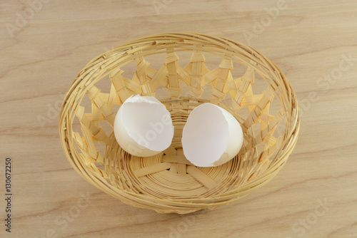 Broken egg shells in wooden basket on table