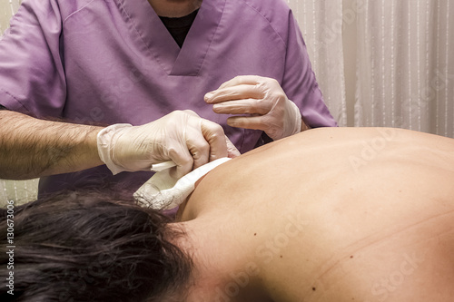 Fisioterapeuta aplicando punción en seco. Tratamiento de sobrecarga muscular.