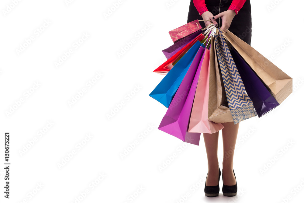 Lower close-up, standng girl holding shopping paper bags and pac