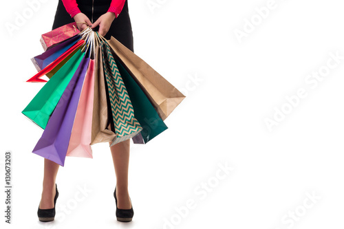Lower close-up, standng woman holding shopping paper bags and pa