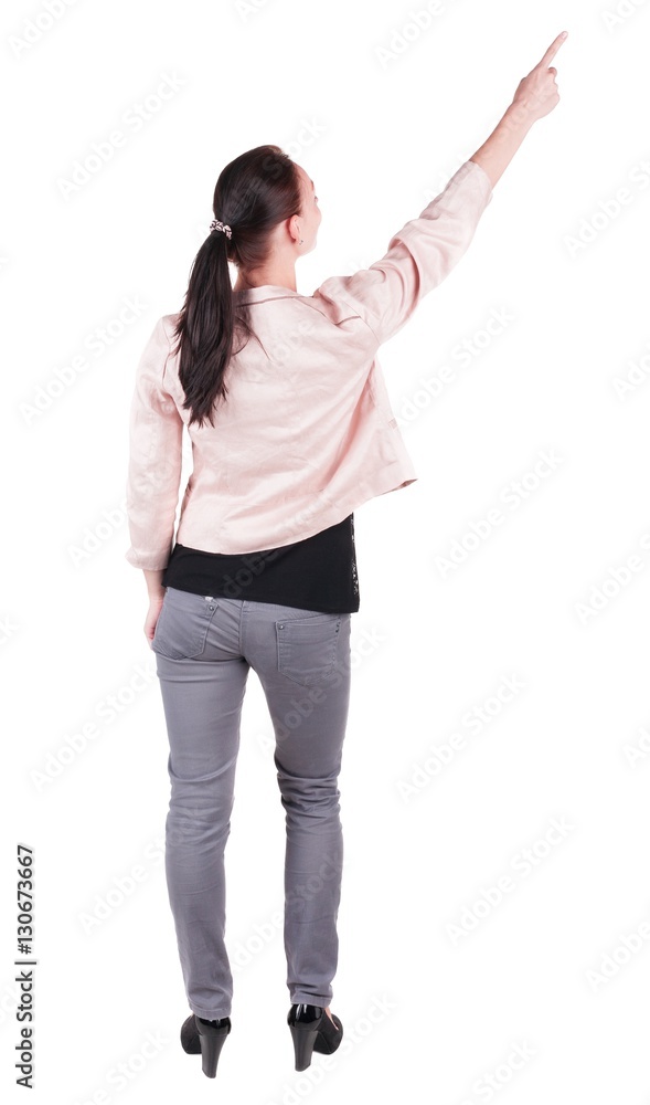 Back view of pointing woman. beautiful brunette girl in jeans. Rear view people collection. backside view of person. Isolated over white background. Back view of pointing woman. beautiful brunette girl in jeans. Rear view people collection. backside view of person. Isolated over white background.