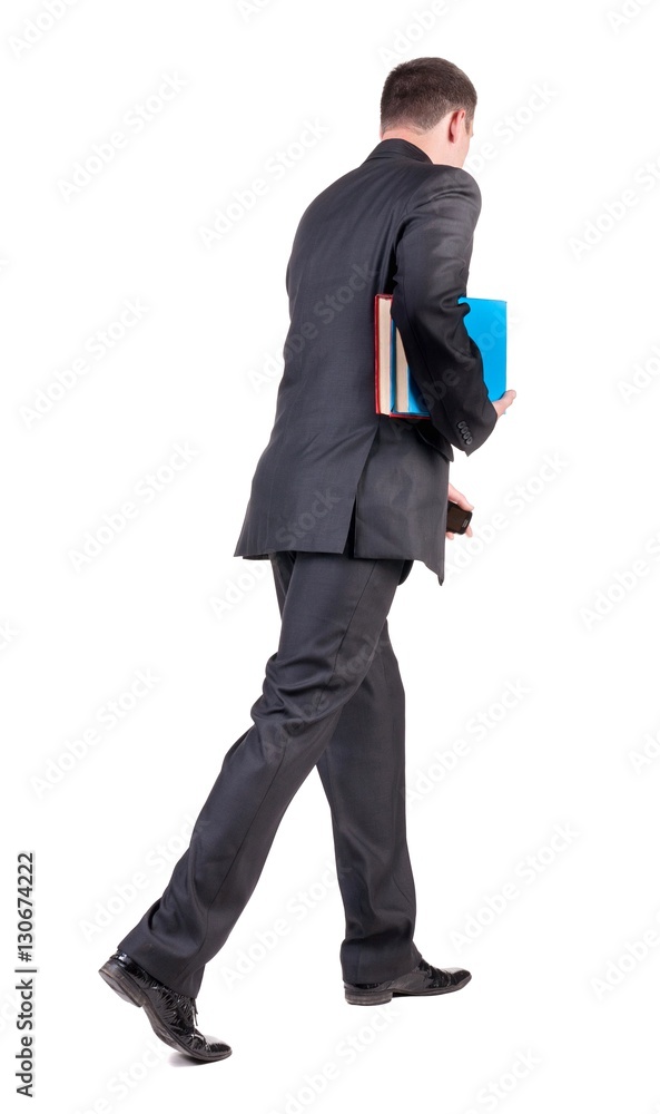 back view of walking business man with books. back view of walking business man with books.
