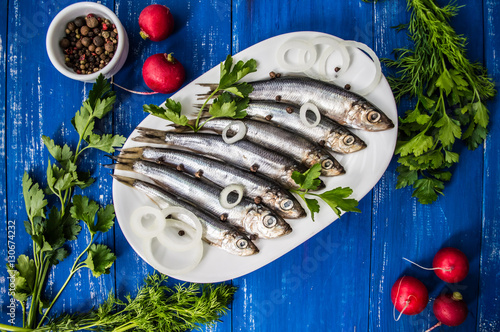 Fotografie herring fish with greens on a wooden blue background