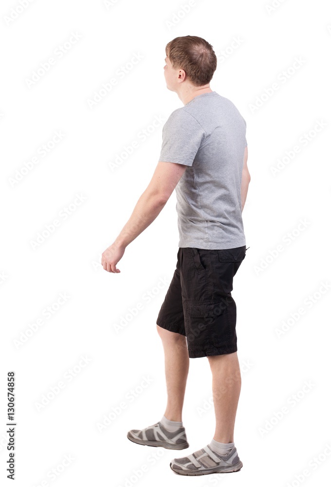 Back view of walking handsome man in shorts and sneakers Back view of walking handsome man in shorts and sneakers