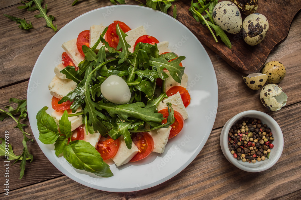 Arugula Salad - Caprese . Wooden background. Top view. Close-up Arugula Salad - Caprese . Wooden background. Top view. Close-up