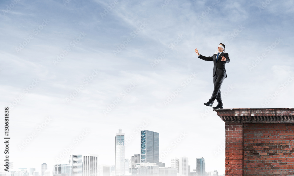 Danger and risk concept with businessman making step from edge Danger and risk concept with businessman making step from edge