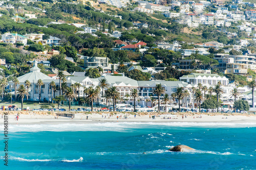 The coastal line of camps bay with the twelve apostle mountains behind it. Camps Bay is one of the most exclusive resort of south africa. photo