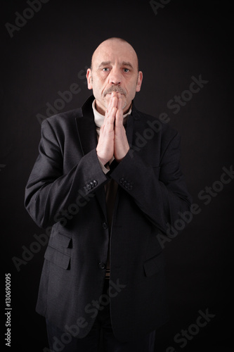 Handsome man doing different expressions in different sets of clothes: prayer