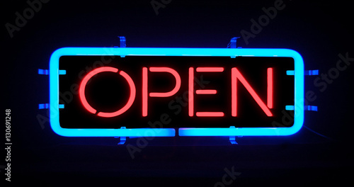 flickering blinking red and blue neon sign on black background, open shop bar sign