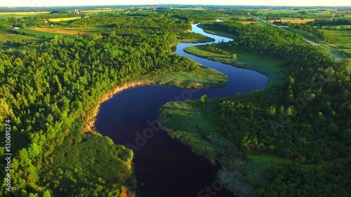 Pristine winding river amid rural wilderness, woodlands.
