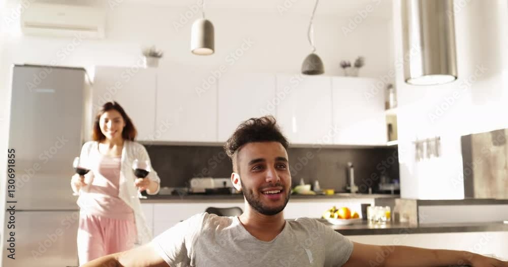Young Mixed Race Couple Morning, Happy Asain Woman Bring Wine Glasses To Hispanic Man Sitting Coach Drinking Together Together Slow Motion Young Mixed Race Couple Morning, Happy Asain Woman Bring Wine Glasses To Hispanic Man Sitting Coach Drinking Together Together Slow Motion