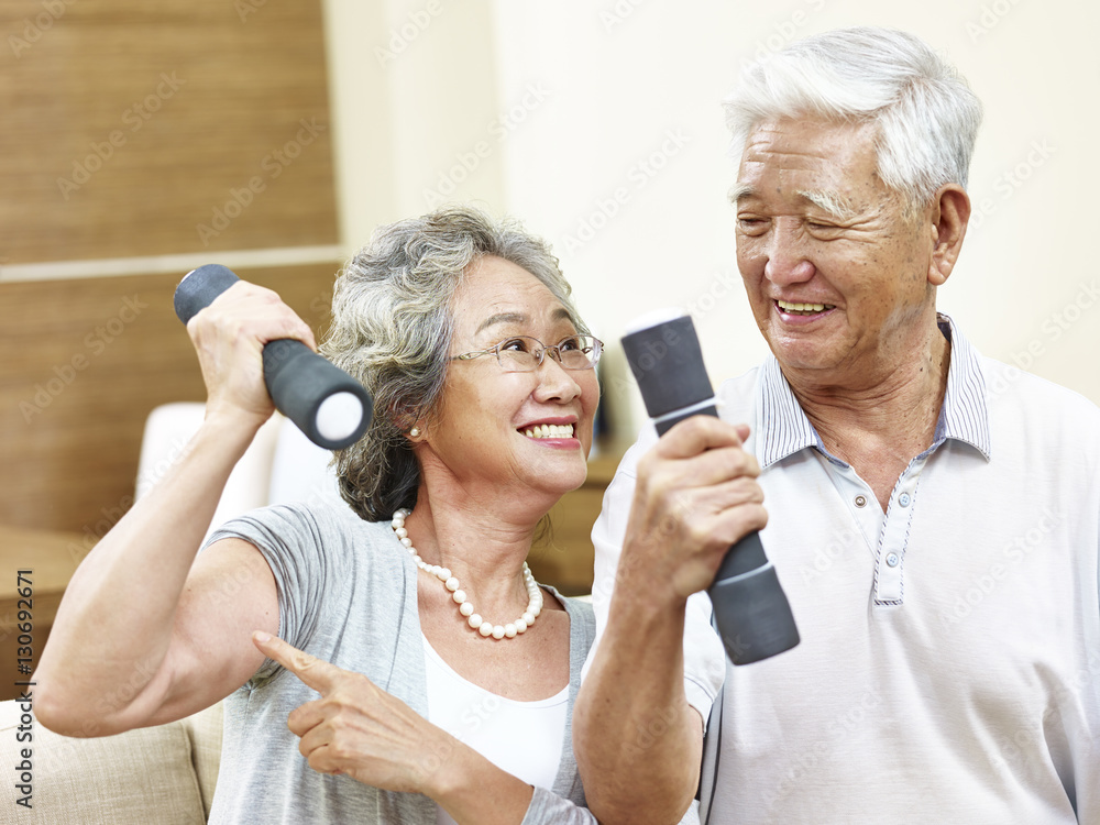 Fototapeta premium senior asian couple exercising using dumbbells