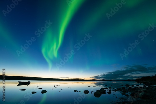 Принти на полотні Aurora at Dusk - Bands of curvy aurora borealis appear over a northern rocky lake right after sunset