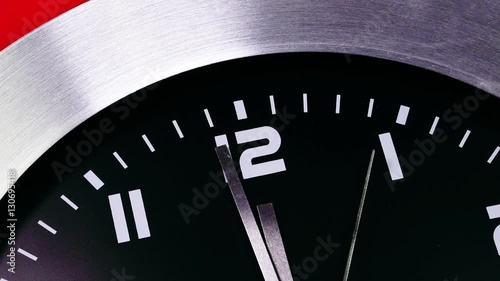 Clock counting down last seconds to the New year on a mechanical clock. Twelve o'Clock on New Year's Eve. Face of a clock indicating midnight. Last minute till New Year,midnight, Red background.