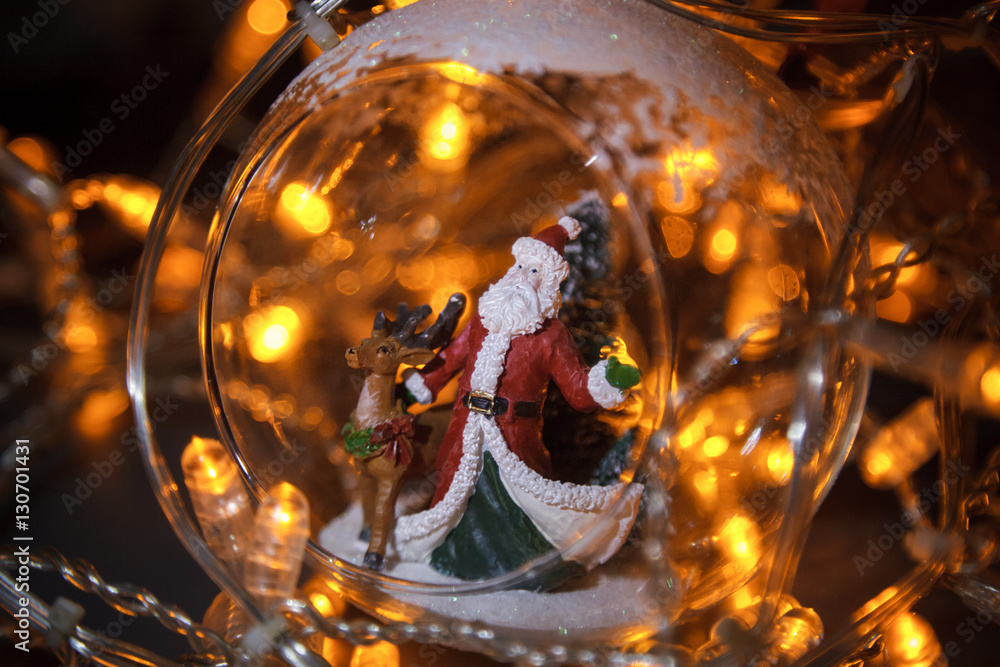 Closeup photo of christmas glass toy with Santa Claus and dear i