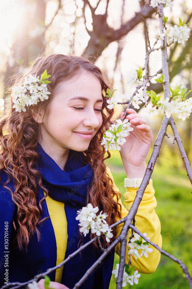 Fototapeta premium happy young woman near a flowering tree in the Park