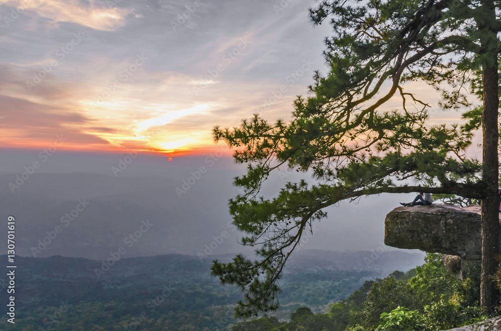 Lonely traveler  sitting and looking sunset on mountain national park phu kradueng  thailand