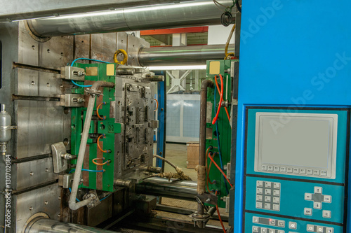 closeup of industrial molding press machine for the manufacture of plastic parts using polymers