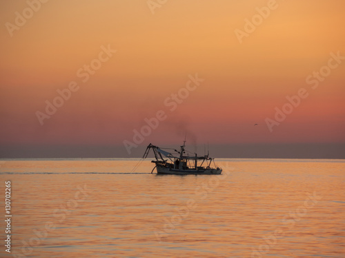 Fishing boats pull their nets at the sunrise. Adriatic cost. Emilia Romagna. Italy. © Matteo Ceruti