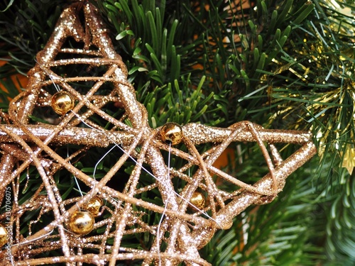 Fragment drewnianej gwiazdy bożonarodzeniowej na tle z gałązek świerkowych