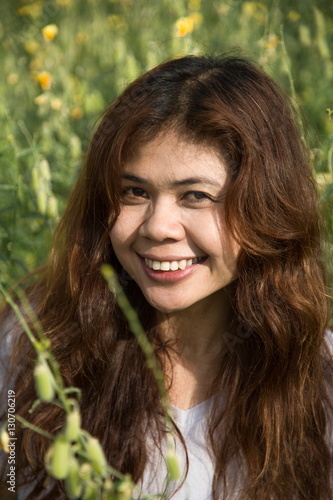asian women with slightly curly in yellow field at summer, Thai