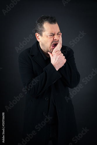 Handsome man doing different expressions in different sets of clothes: toothache