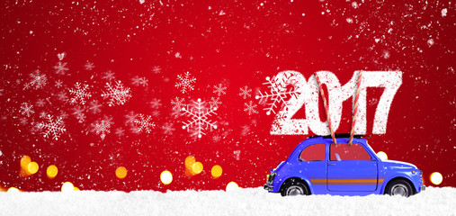 Blue retro toy car delivering Christmas or New Year 2017 on festive red background