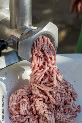 Close detail of meat grinder processing meat