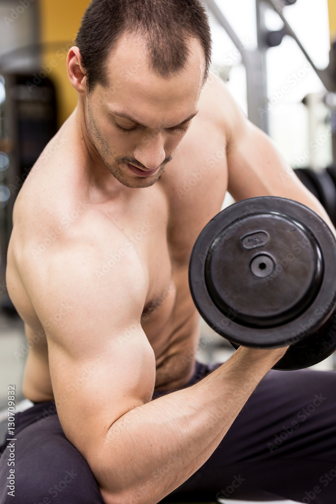 bodybuilder man with a dumbbell in fitness club bodybuilder man with a dumbbell in fitness club
