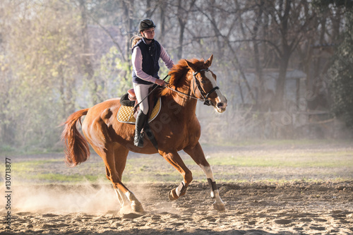 Valokuvatapetti Young girl riding a horse