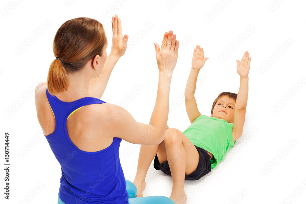 Kid boy repeating physical exercises after trainer Kid boy repeating physical exercises after trainer
