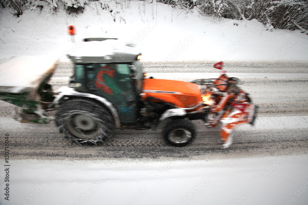 Motion blurred Tractor deicing and cleaning a road in winter. Motion blurred Tractor deicing and cleaning a road in winter.