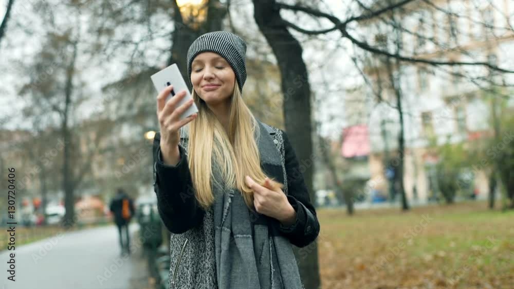 Happy girl having a videocall in the autumnal park, steadycam shot
Happy girl having a videocall in the autumnal park, steadycam shot