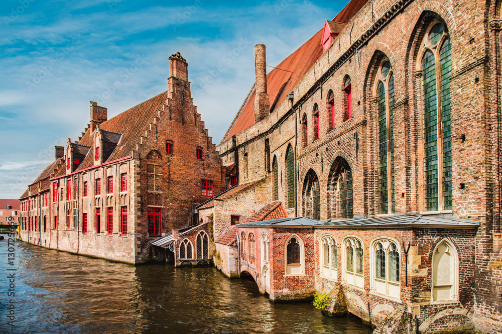Historical brick buildings along beautiful canals in spring in Bruges, Belgium