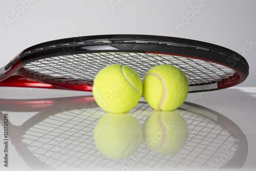 Tennis racket and two balls for playing tennis on a black background