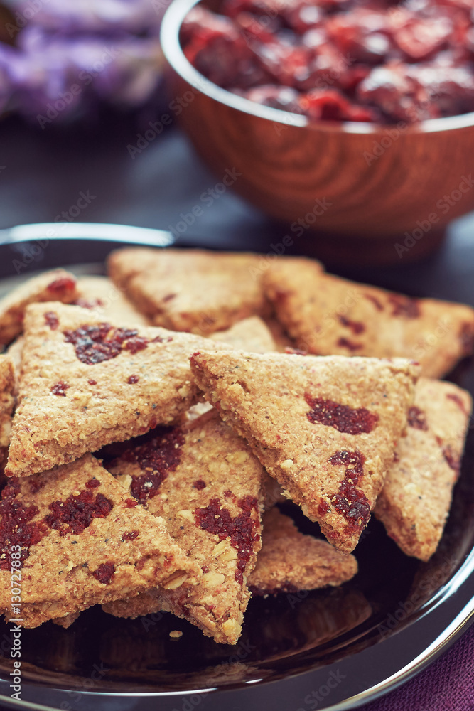 Whole wheat cookies with dried cranberries on black wooden background Whole wheat cookies with dried cranberries on black wooden background