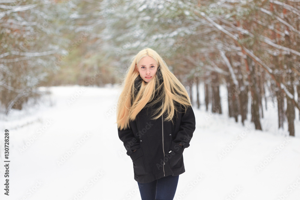girl in the winter woods on a snowy road