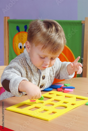 Little boy playing and learning in preschool