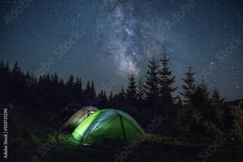 Tourists tents in the wood under the Milky Way