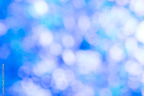 Blue bokeh glitter defocused ray lights abstract background.