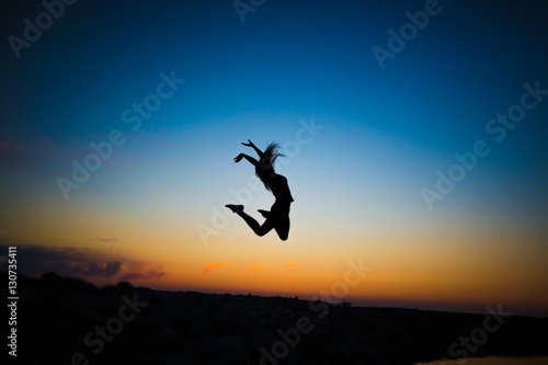 silhouette of girl at sunset. jump. happiness