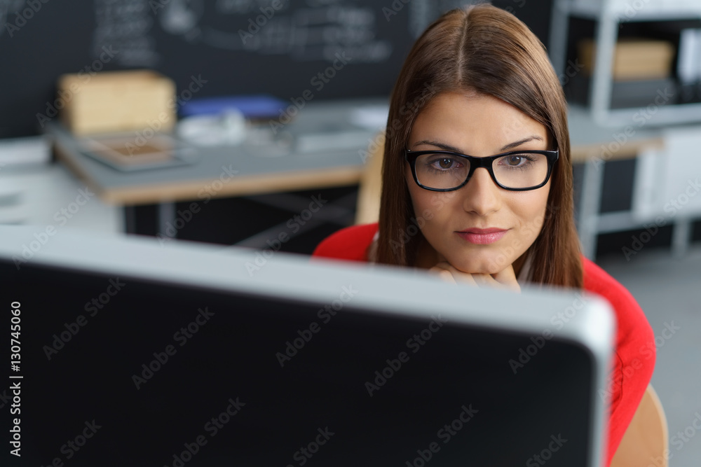 frau im büro schaut konzentriert auf ihren pc frau im büro schaut konzentriert auf ihren pc