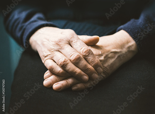 Hands of senior woman, woman sitting with her hands folded, selective shallow focus