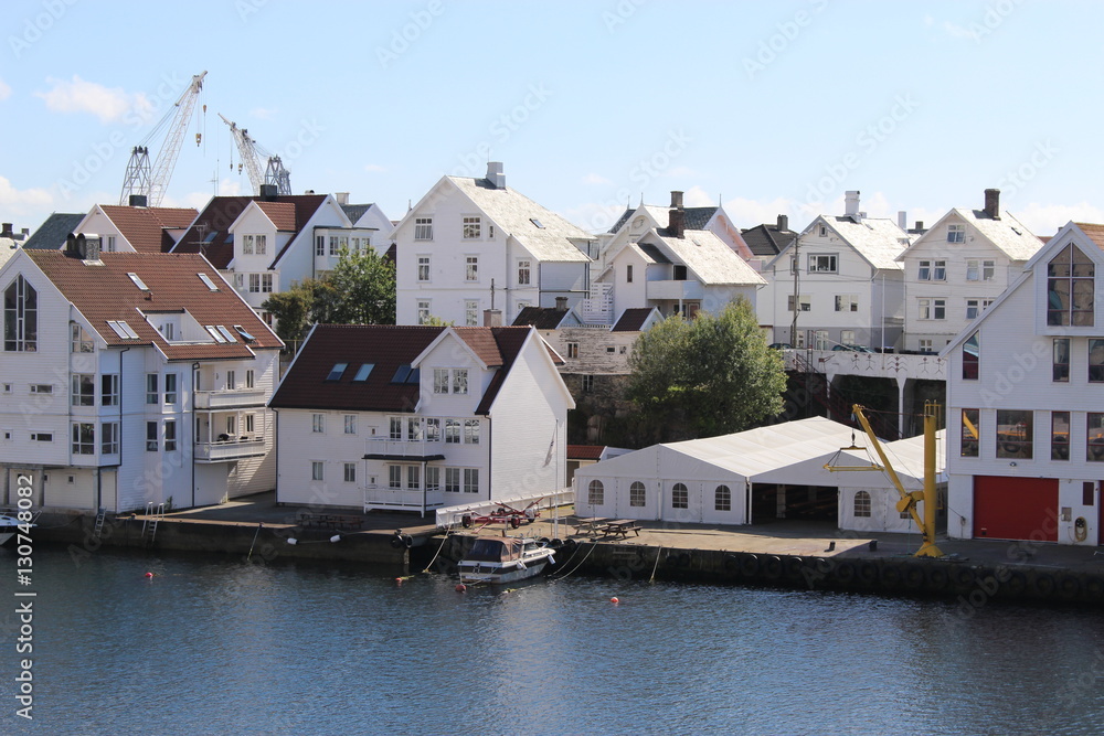 White wooden houses in low sun. On the island Risoy, part oft he town Haugesund in Norway, Europe. Haugesund is located on the west coast of Norway, between Bergen and Stavanger.